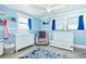 Light blue Bedroom with ceiling fan, crib, dresser, and a gray recliner chair at 9802 N Oregon Ave, Tampa, FL 33612