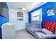 Well-appointed Bedroom is decorated with blue walls, Star Wars art and features crib, cabinets, and recliner at 9802 N Oregon Ave, Tampa, FL 33612