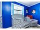 Stylish Bedroom decorated with bright blue walls and Star Wars artwork features a crib and recliner at 9802 N Oregon Ave, Tampa, FL 33612