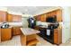 The open kitchen features wood cabinets, stone countertops and a kitchen island at 9802 N Oregon Ave, Tampa, FL 33612