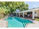 Beautifully landscaped pool with covered patio is perfect for entertaining guests at 9802 N Oregon Ave, Tampa, FL 33612
