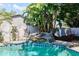Sparkling pool with waterfall feature surrounded by lush tropical landscaping at 9802 N Oregon Ave, Tampa, FL 33612