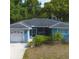 Charming home featuring a one-car garage, screened porch, and lush landscaping at 10980 104Th Ave, Largo, FL 33778