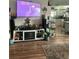 Comfortable living area with a large TV, decorative shelving, and laminate wood flooring at 10980 104Th Ave, Largo, FL 33778