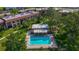 An aerial view of a community pool with lounge chairs and mature trees in the surrounding area at 12900 Vonn Rd # D202, Largo, FL 33774