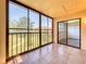 Screened balcony with tiled floors overlooking green space at 12900 Vonn Rd # D202, Largo, FL 33774