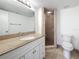 Bathroom featuring granite countertop, walk-in shower, and tiled floors at 12900 Vonn Rd # D202, Largo, FL 33774