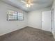 Bedroom with carpet floors, a window with blinds, and access to a closet or storage area at 12900 Vonn Rd # D202, Largo, FL 33774