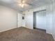 Comfortable bedroom featuring carpet, an open closet, and a doorway to the en-suite bathroom at 12900 Vonn Rd # D202, Largo, FL 33774