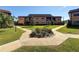 Beautiful condo building with well-manicured lawn, landscaping, and mature trees at 12900 Vonn Rd # D202, Largo, FL 33774