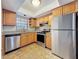 Well-equipped kitchen featuring stainless steel appliances, wood cabinets, and granite countertops at 12900 Vonn Rd # D202, Largo, FL 33774