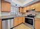 Bright kitchen with stainless steel appliances, granite countertops, and wood cabinetry at 12900 Vonn Rd # D202, Largo, FL 33774