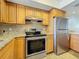 Updated kitchen with stainless steel appliances, granite counters, and ample cabinet space at 12900 Vonn Rd # D202, Largo, FL 33774