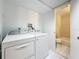 Laundry room featuring washer and dryer, with bathroom access at 12900 Vonn Rd # D202, Largo, FL 33774