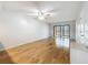 A naturally lit, spacious living room featuring stylish hardwood floors and glass sliding doors to the balcony at 12900 Vonn Rd # D202, Largo, FL 33774
