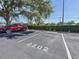 Assigned parking spot with a red SUV parked under the shade of a large tree at 12900 Vonn Rd # D202, Largo, FL 33774