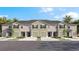 Charming townhome with a well-manicured lawn, dark shutters, and attached one car garage at 17261 Bigleaf Mahogany Ln, Land O Lakes, FL 34638