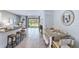 Open floor plan featuring a dining table, kitchen island, and access to backyard at 17261 Bigleaf Mahogany Ln, Land O Lakes, FL 34638