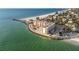 Stunning aerial view of a beachfront condo complex with a pool, palm trees, and ocean views at 200 1St Ave # 309, St Pete Beach, FL 33706