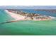 Panoramic aerial view of a coastal condo complex, pier, beach, and beautiful blue water at 200 1St Ave # 309, St Pete Beach, FL 33706