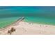Scenic aerial of the shore featuring beach, pier, and clear ocean water at 200 1St Ave # 309, St Pete Beach, FL 33706