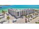 Aerial view of condo building with parking lot, showing proximity to beach at 200 1St Ave # 309, St Pete Beach, FL 33706