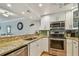 Modern kitchen featuring granite countertops, stainless steel appliances, and white cabinetry at 200 1St Ave # 309, St Pete Beach, FL 33706