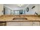 Kitchen counter with a stainless steel sink and granite countertops, offering a view into the living room at 200 1St Ave # 309, St Pete Beach, FL 33706