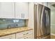 Kitchen cabinet close-up showcasing new stainless steel refrigerator and granite counter tops at 200 1St Ave # 309, St Pete Beach, FL 33706