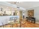 Open-concept living area with a breakfast bar connecting the kitchen and a dining table with clear chairs at 200 1St Ave # 309, St Pete Beach, FL 33706