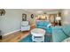 Inviting living room with blue sofa, matching easy chair, and adjacent kitchen access at 200 1St Ave # 309, St Pete Beach, FL 33706