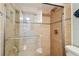 Tiled shower with glass door and grab bar, showcasing modern design and accessibility at 200 1St Ave # 309, St Pete Beach, FL 33706