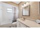 Well-lit bathroom features a neutral color palette, framed mirror, and shower-tub combo at 2013 Capri Rd, Valrico, FL 33594