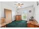 Well-lit room with wooden desk, green carpet, ceiling fan, and window view at 2013 Capri Rd, Valrico, FL 33594