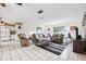 Open-concept living room with tiled floors, comfortable seating, and a ceiling fan at 2013 Capri Rd, Valrico, FL 33594