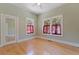 Bright, airy bedroom with hardwood floors, large windows, and simple red and white curtains at 202 39Th S Ave, St Petersburg, FL 33705