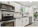 Updated kitchen features stainless steel appliances, white cabinets, and granite countertops at 2230 Melrose S Ave, St Petersburg, FL 33712