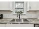 Updated kitchen features granite countertops, white cabinetry, and stainless steel sink at 2230 Melrose S Ave, St Petersburg, FL 33712