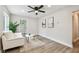 Bright living room with a modern ceiling fan, white sofa, wood-look floors, and natural light at 2230 Melrose S Ave, St Petersburg, FL 33712