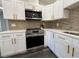 Bright kitchen with stainless steel appliances, quartz countertops, white cabinets, and stylish backsplash at 2254 66Th S Ave, St Petersburg, FL 33712