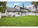 Large backyard with manicured grass, and a home with both white brick and gray siding at 226 Willowick Ave, Temple Terrace, FL 33617