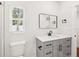 Bathroom featuring a vanity with black hardware, a toilet, and a window that provides natural light at 226 Willowick Ave, Temple Terrace, FL 33617