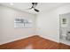 Bedroom with hardwood floors, a ceiling fan, natural light, and an ensuite bathroom at 226 Willowick Ave, Temple Terrace, FL 33617