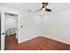 Simple bedroom with hardwood floors features a ceiling fan and an adjacent bathroom at 226 Willowick Ave, Temple Terrace, FL 33617