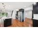 Modern kitchen features stainless steel appliances, an island with a quartz countertop and wooden floors at 226 Willowick Ave, Temple Terrace, FL 33617