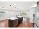 Bright living room with hard wood floors features modern lighting, a kitchen and updated appliances at 226 Willowick Ave, Temple Terrace, FL 33617