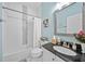 Updated bathroom featuring a shower-tub combo with a white shower curtain and a stylish mirror at 2829 Maple Brook Loop, Lutz, FL 33558