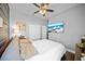 Comfortable bedroom featuring a ceiling fan, a TV, neutral walls, and wood floors at 2829 Maple Brook Loop, Lutz, FL 33558