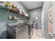Well-organized laundry room with modern washer and dryer, plus shelving and accessories at 2829 Maple Brook Loop, Lutz, FL 33558