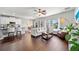 Open concept living space featuring hardwood floors, plush seating, and seamless flow to dining and kitchen at 2829 Maple Brook Loop, Lutz, FL 33558